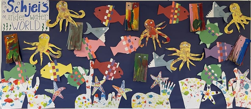 A colorful school bulletin board featuring different sea creatures, both painted and made of construction paper